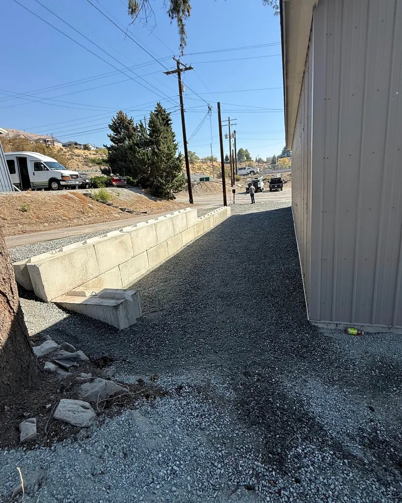 The same alley surfaced in dark crushed rock with the finished block wall along the road